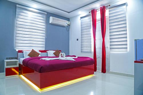 a bedroom with a red bed in a room with windows at M aples Jacks Place in Cavelossim