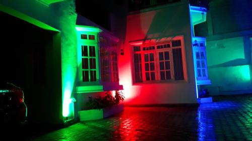 a house with red and green lights on a street at Jal,Min Homestay in Kandy