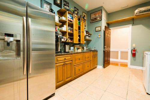 uma cozinha com um frigorífico de aço inoxidável e armários de madeira em Oak Park Inn Enjoy Free Wine Beer Snack Drink em Arcadia