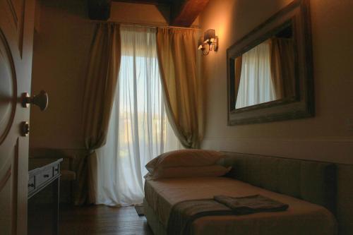 a hotel room with a bed and a window at San Giovanni Relais in San Giovanni in Marignano