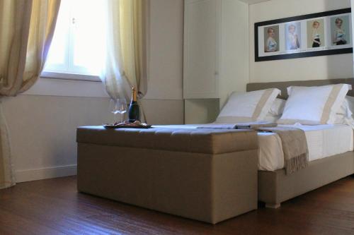 a bed with a ottoman next to a window at San Giovanni Relais in San Giovanni in Marignano