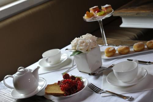 a table with a tea set with desserts and tea cups at San Giovanni Relais in San Giovanni in Marignano