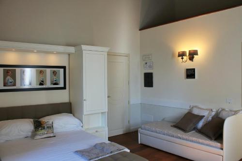 a bedroom with a bed and a bench in it at San Giovanni Relais in San Giovanni in Marignano