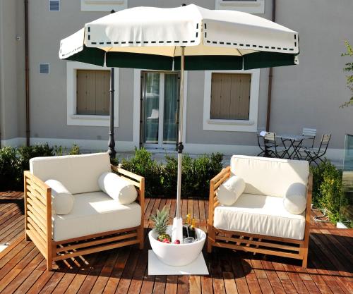 two chairs under an umbrella on a patio at San Giovanni Relais in San Giovanni in Marignano