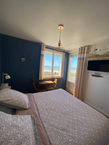1 dormitorio con 1 cama grande y 2 ventanas en La Villa plein vent "Lumière du Cap" vue mer en Barneville-Carteret