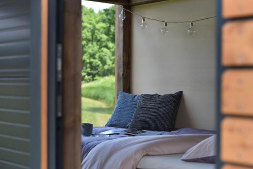 łóżko w pokoju z oknem w obiekcie Glamping Hluboká w mieście Hluboká nad Vltavou