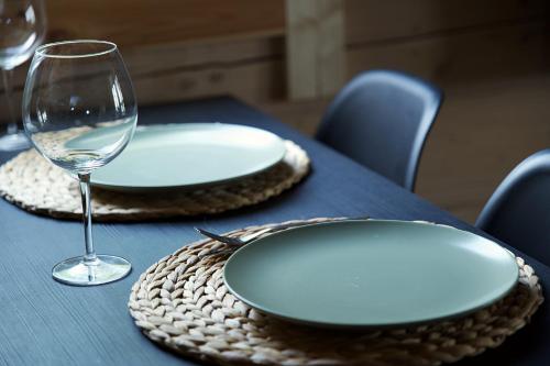 a table with two plates and a glass of wine at Chill House in Miežonys