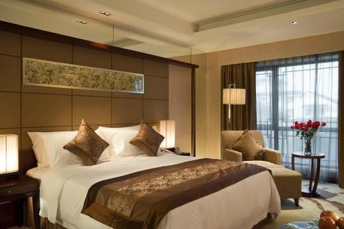 a hotel room with a large bed and a chair at Wyndham Garden Suzhou in Suzhou