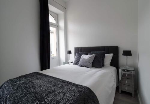 a white bedroom with a bed and a window at EXECUTIVE DOUBLE ROOM WITH EN-SUITE IN GUEST HOUSE CITY CENTRE r4 in Luxembourg
