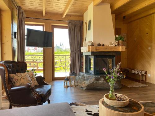 a living room with a couch and a fireplace at Osada Snozka in Kluszkowce