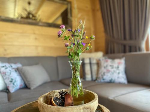 a vase with flowers on a table in a living room at Osada Snozka in Kluszkowce