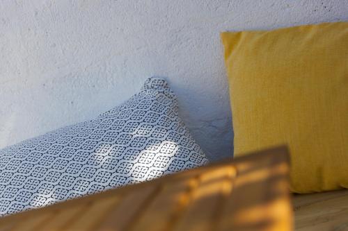 a white pillow next to a yellow pillow next to at Hillywych Studio in Redruth