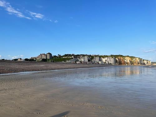 uma praia com pedras no fundo e água em le Petit futé 112 em Biville-sur-Mer