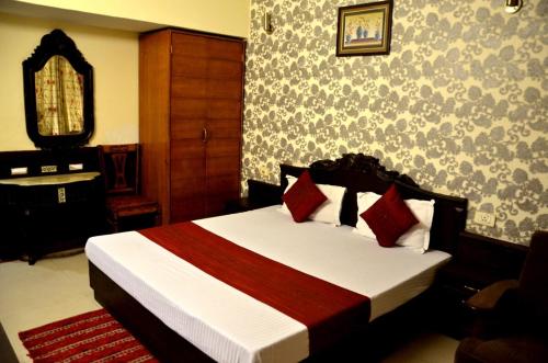 a bedroom with a bed and a dresser and a mirror at Hotel City Paradise in Chandīgarh