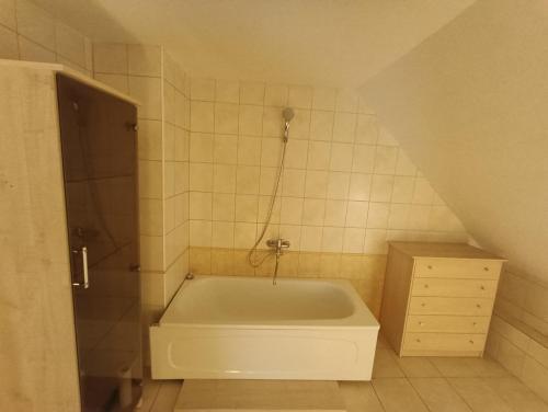 ein Bad mit einer Badewanne im Dachgeschoss in der Unterkunft Surf Apartments in Melnrage in Klaipėda