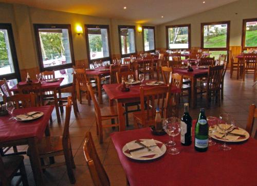 un restaurante con mesas y sillas y botellas de vino en Hotel Parrilla el Zangano, en Boal