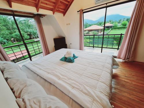 a bedroom with a large bed with a teddy bear on it at Volcano view house la Fortuna in Fortuna