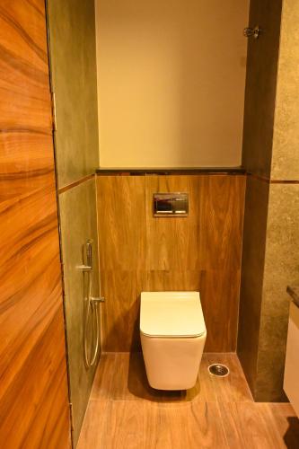 a small bathroom with a toilet and a shower at Kalki Hotel in Port Blair