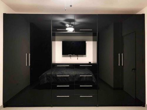 a black entertainment center with a flat screen tv in it at Casa moderna y elegante en el corazón de Ensenada! in Ensenada