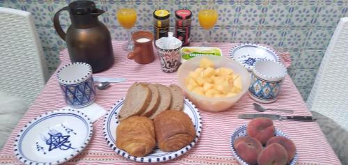 a table with plates of food and bread and fruit at Dar Warda in Bizerte