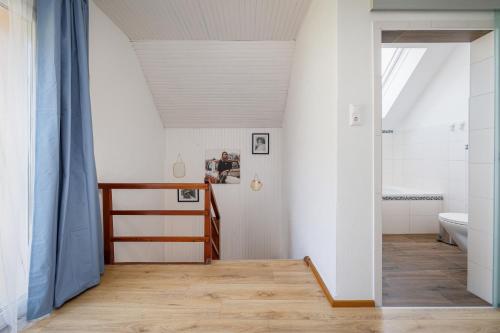 a bathroom with white walls and a wooden floor at Ferienhaus Auszeit Natur in Villach