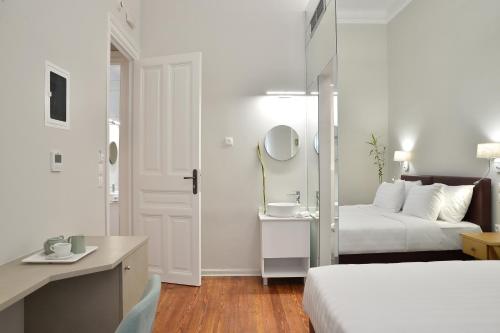 a bedroom with two beds and a sink and a mirror at 1900 ATHENIAN HOUSE in Athens