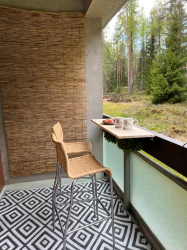 a chair sitting on a balcony with a table at Forest apartments in Kouvola