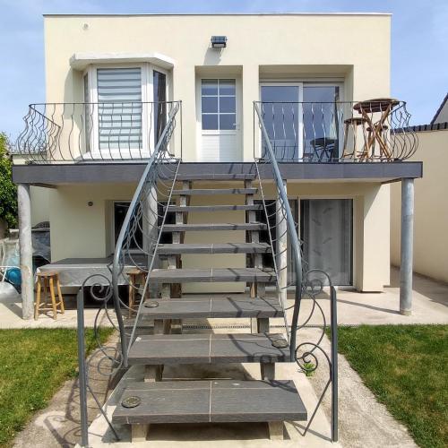 un escalier en métal menant à une maison dans l'établissement Maison chaleureuse avec parking gratuit sur place, à Coulogne