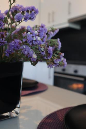 a vase filled with purple flowers on a table at Patroclos SeaView in Sounio