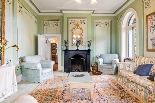 a living room filled with furniture and a fire place at Colhurst House in Mount Gambier