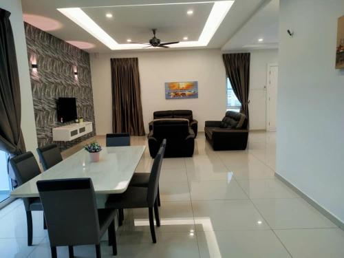 a dining room and living room with a table and chairs at My Home Kayangan Villa Malacca C10 in Melaka