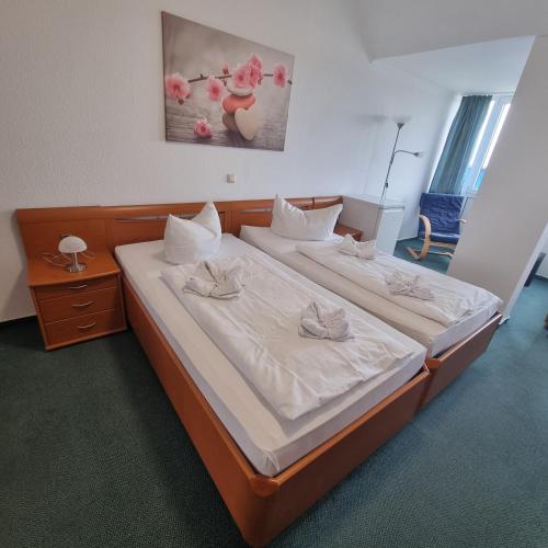a bedroom with two beds with white sheets at Müritz-Pension Waren in Waren