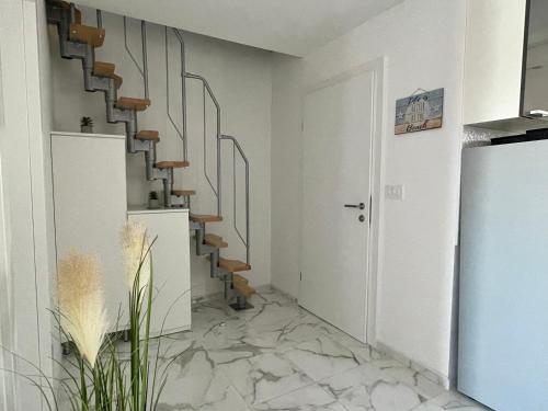 a hallway with a spiral staircase with marble floors at SeaScape - Relaxing beach home, steps from the water! in Bilice