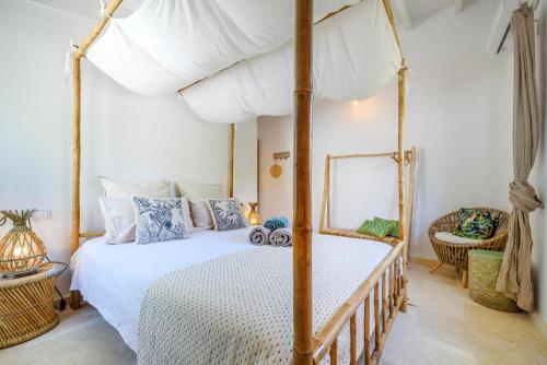 a bedroom with a canopy bed and a chair at Can Torres in Pòrtol