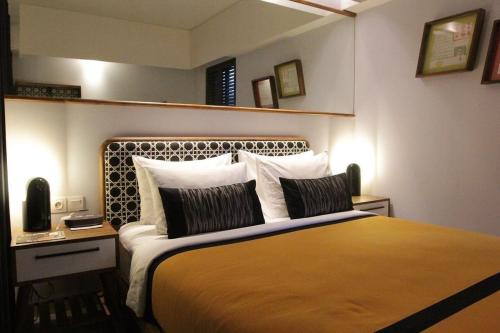 a bedroom with a large bed and a mirror at Kosenda Hotel in Jakarta
