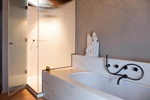 a bathroom with a tub and a glass shower at Paradis Agricole in Pietrasanta