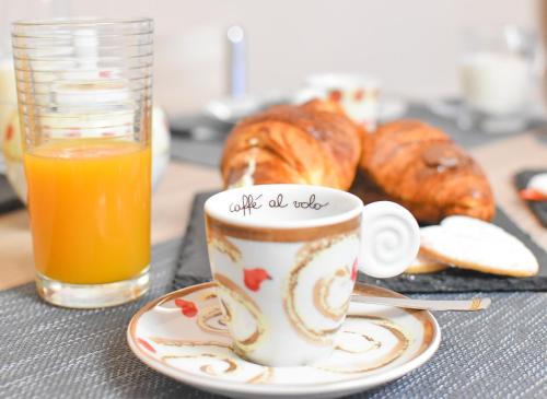 a cup of coffee and a plate of pastries and a glass of juice at B&B L'Arenaria in Pietrapertosa