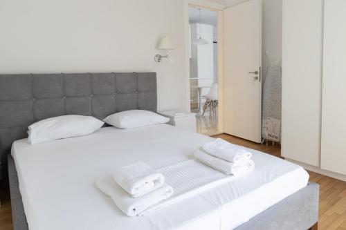 ein Schlafzimmer mit einem weißen Bett und Handtüchern darauf in der Unterkunft Acropolis Urban Life in Athen