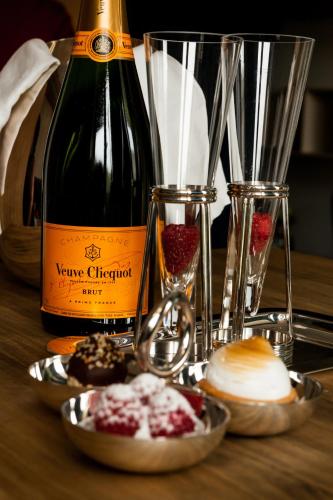 a bottle of wine and a plate of food on a table at Suite Aux Anges in Antwerp