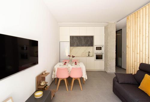 sala de estar con mesa y sillas rosas en La Habitación del Arquitecto en Granada