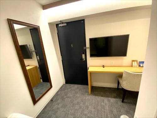a room with a desk with a mirror and a television at Hotel Prezier Akihabara - Vacation STAY 21812v in Tokyo