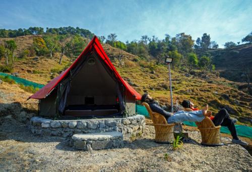 two people sitting in chairs in front of a tent at Crazy Cub Camp in Bīr