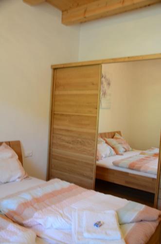 um quarto com 2 camas e um grande armário em Ferienwohnung Waldköhlerei em Michelbach