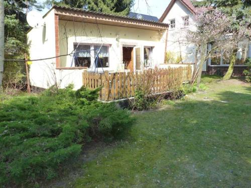ein Haus mit einem Holzzaun im Hof in der Unterkunft Ferienhaus "Fleesensee" Objekt ID 11956 in Silz