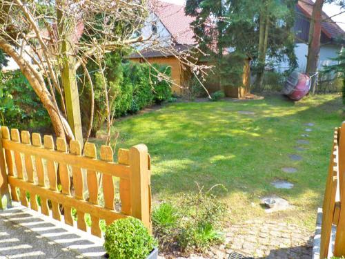 a wooden bench sitting in a yard next to a lawn at Ferienhaus "Fleesensee" Objekt ID 11956-6 in Silz
