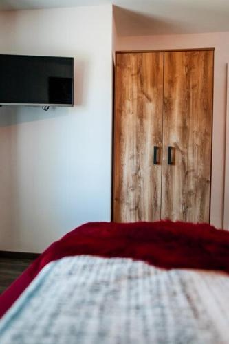 a bedroom with a bed and a wooden door at Ferienwohnungen Finkengrund in Büren