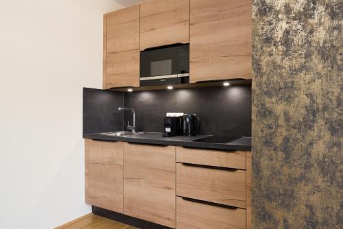 a kitchen with a sink and a microwave at Vienna Stay Apartments Linzerstrasse in Vienna