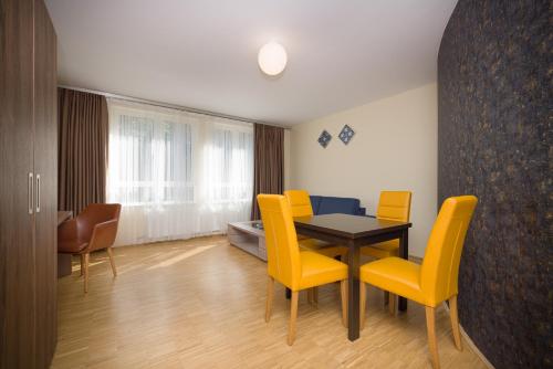 a dining room with a table and yellow chairs at Vienna Stay Apartments Linzerstrasse in Vienna