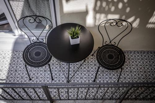 a black table and two chairs with a plant on it at The Beetle House in Volos