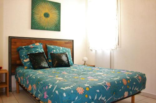 een slaapkamer met een bed met een blauw dekbed bij Appartement cozy aux Beaux Arts - Casa La Selva in Montpellier